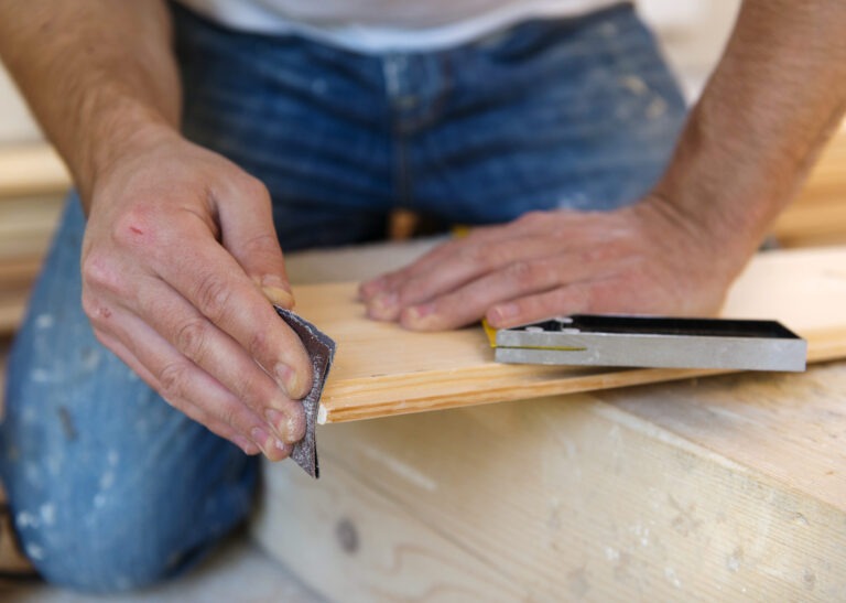 Handyman installing wooden floor in new house