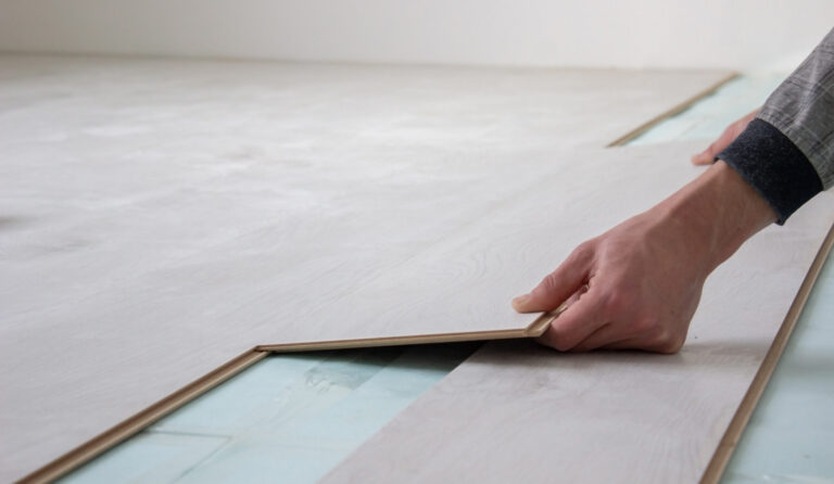Workers' hands install a wooden laminate floor. Home renovation with wooden floors with measurements. selective focus